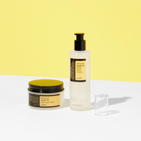 COSRX Advanced Snail 92 All In One Cream ansiktskräm tillsammans med snail essence i produktserie på gul bakgrund
